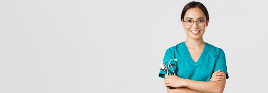 Smiling nurse in teal scrubs with glasses and stethoscope, arms crossed against white background showing professionalism.